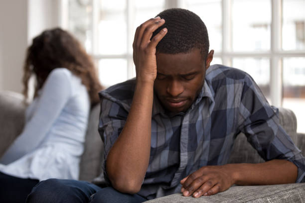 istock Unhappy black married couple sitting on couch at home 1051381608