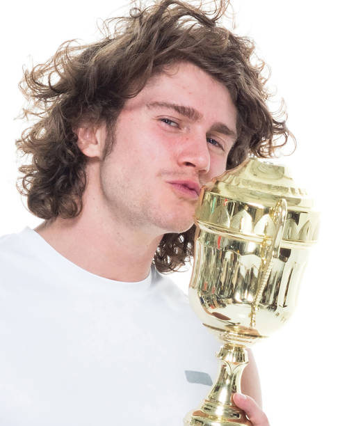 istock Man holding a trophy and football 1051385078
