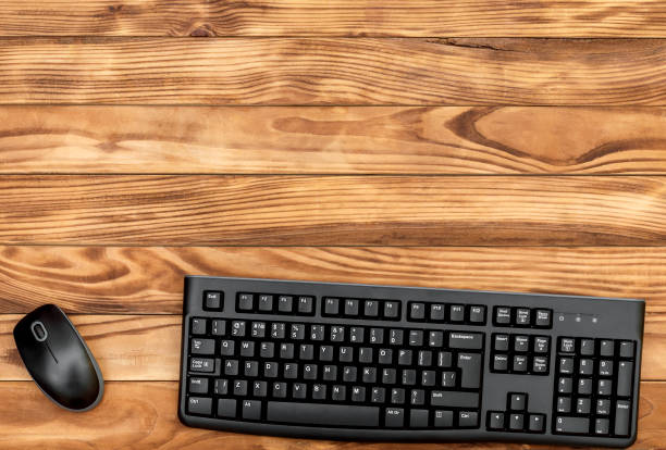 istock Computer mouse and keyboard on wooden background. Top view. Space for text. 1051385690