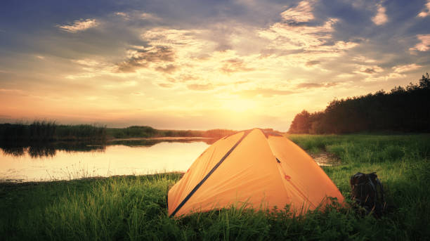 istock Orange tent by the lake 1051389178