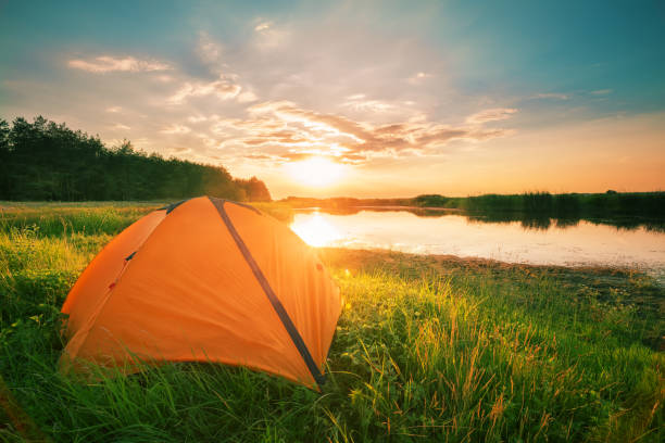 istock Orange tent by the river in the evening 1051389204