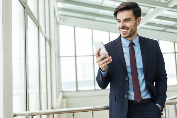 istock Elegant businessman using smart phone, hand in pocket 1051397868