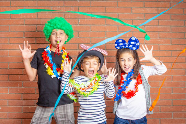 istock Three little boys celebrating a party with a wall in the background 1051401372