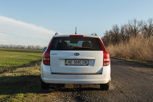 Dnipropetrovsk region, Ukraine - march 25, 2015: Kia Ceed white color on the road through the fields