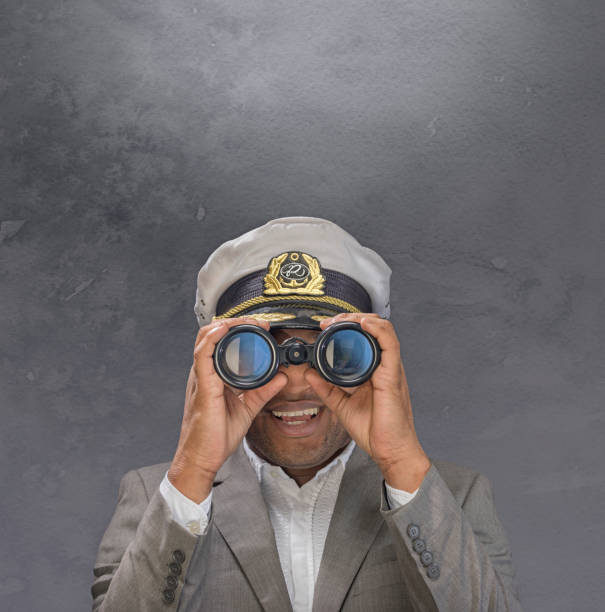 Boat captain showing looking through binoculars towards you