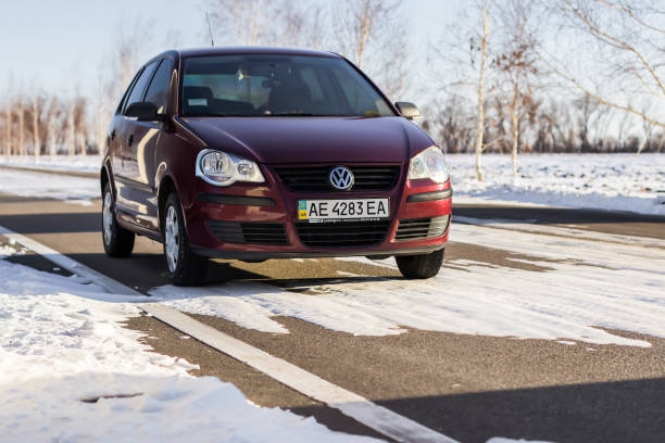 volkswagen polo kastanienbrauner farbe auf der winter-straße, nicht-städtisches - winter non urban scene snow tree stock-fotos und bilder