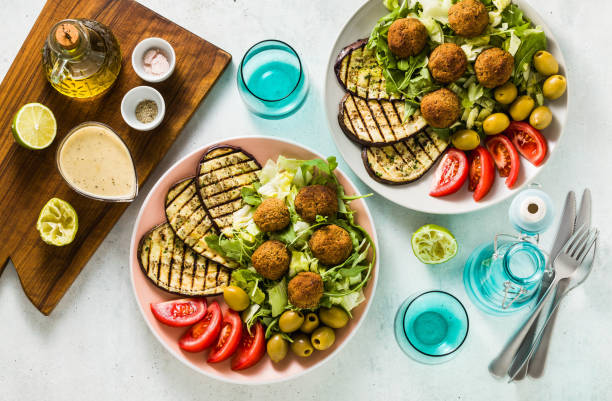 istock an appetizing dinner or lunch from a salad with tomatoes, grilled eggplants and legume falafel with sesame tahini dressing. Vegan healthy food for the whole family 1051420082