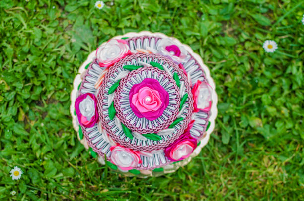 Pink birthday cake with 3D origami on green grass