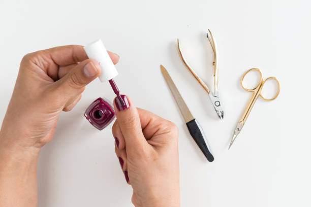 istock Womans Hand Applying Nail Polish 1051427514