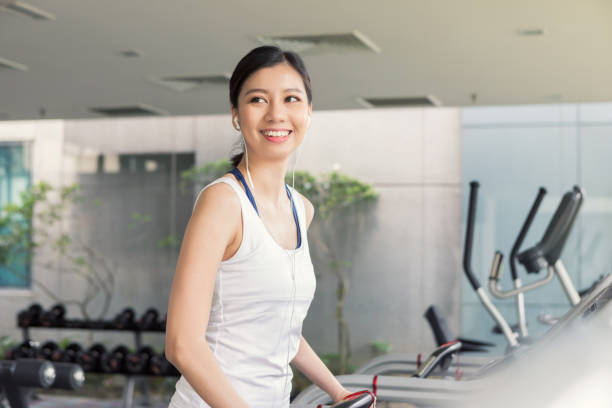 istock Woman uses treadmill in gym 1051434888