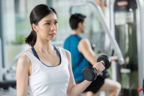 istock Young woman lifting hand weight 1051434908