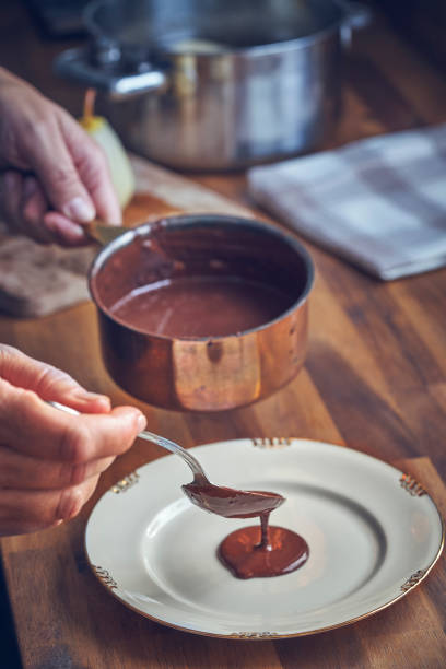 istock Preparing Poached Pears in Vanilla Lemon Syrup glazed with Dark Chocolate 1051443150
