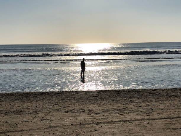 istock woman on a tropical beach in the sunset 1051447330