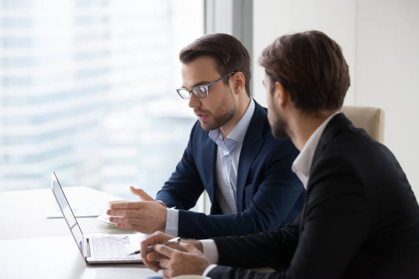 istock Focused male managers discussing project busy at laptop 1051453314