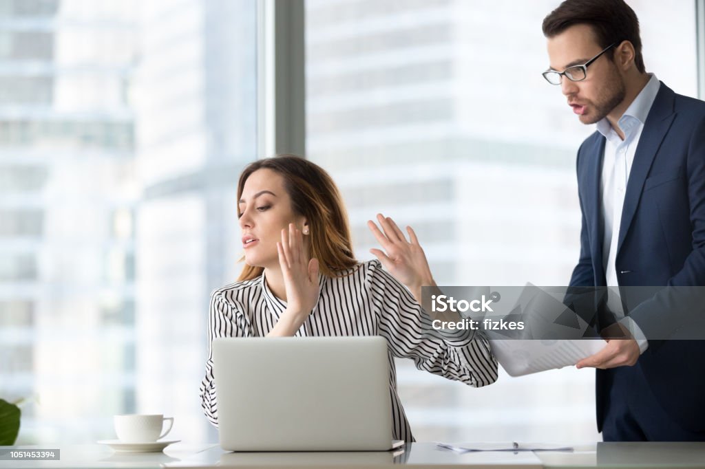 Bothered businesswoman rejecting accept document from colleague Tired bothered businesswoman abstracting from work refuse accept or consider report, annoyed female ceo gesturing rejecting mad business client or subordinate not looking at papers or documents Ignoring Stock Photo