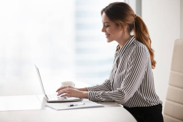 istock Happy businesswoman texting at laptop distracted from work 1051453408