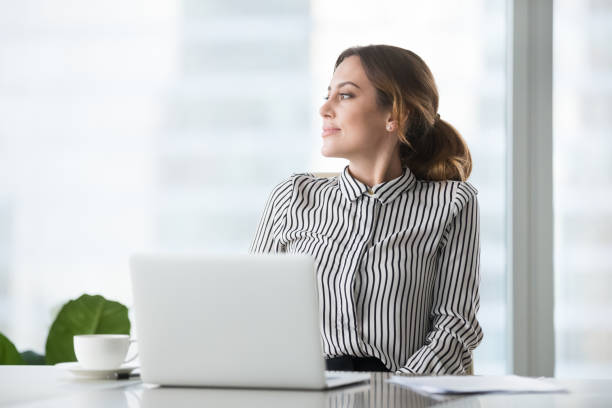 Smiling businesswoman thinking or dreaming distracted from work