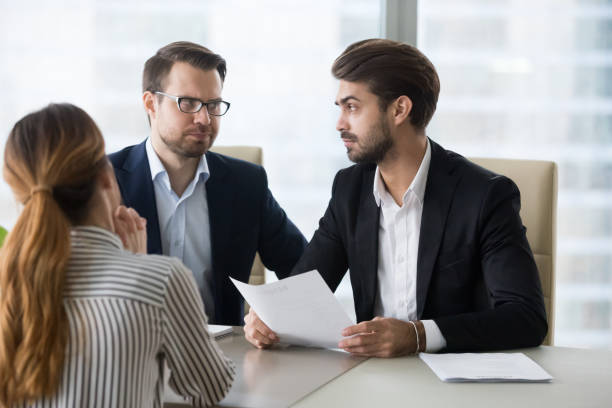 istock Dissatisfied recruiters exchange skeptic glance disliking female candidate 1051453450