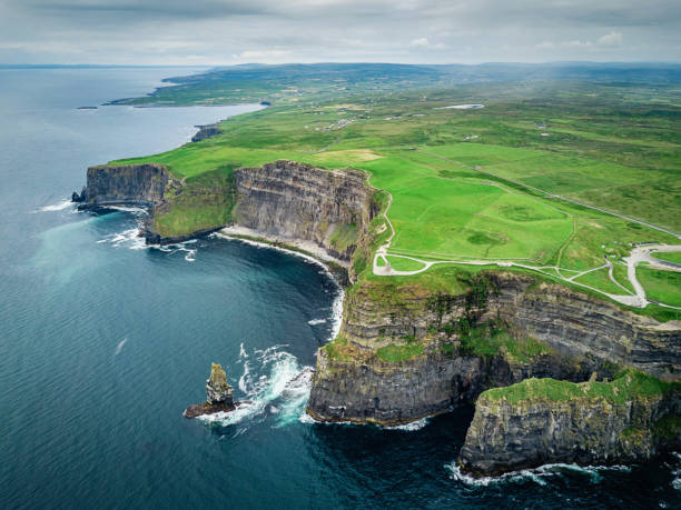 Cliffs of Moher Ireland Wild Atlantic Way Areal drone pointt of view towards the beautiful and famous Cliffs of Moher under dramatic skyscape in summer. Burren Region, County Clare, Ireland natural landmark photos stock pictures, royalty-free photos & images