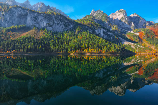 istock autumn scenery with Dachstein mountain summit reflecting in crystal clear Gosausee mountain lake in fall 1051462914