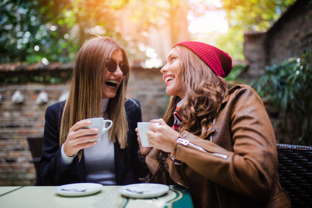 istock Two girls sitting at cafe and drinking coffee 1051466852