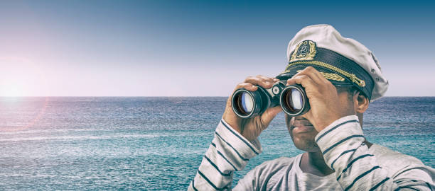 Boat captain showing looking through binoculars towards horizon