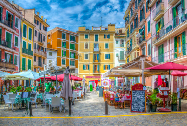 PALMA DE MALLORCA, SPAIN, MAY 18, 2017:View of a narrow street in the historical center of Palma de Mallorca, Spain PALMA DE MALLORCA, SPAIN, MAY 18, 2017:View of a narrow street in the historical center of Palma de Mallorca, Spain store wall surrounding wall facade stock pictures, royalty-free photos & images