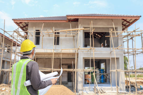 istock Professional engineer architect worker with protective helmet and blueprints paper at house building construction site 1051511278
