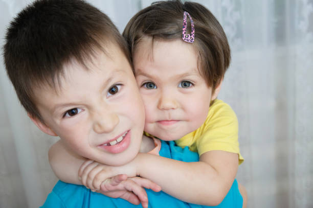 wrogość między bratem i siostrą. rodzeństwo dzieci portret - chłopiec i dziewczynka, razem. portret rodzinny z dziećmi w różnym wieku. domowy styl życia.  rodzina z dzieciństwa - animosity zdjęcia i obrazy z banku zdjęć