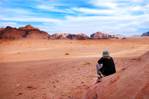 A woman tourist looks at the wonderful landscape view of Wadi Rum, a protected desert wilderness in southern Jordan.