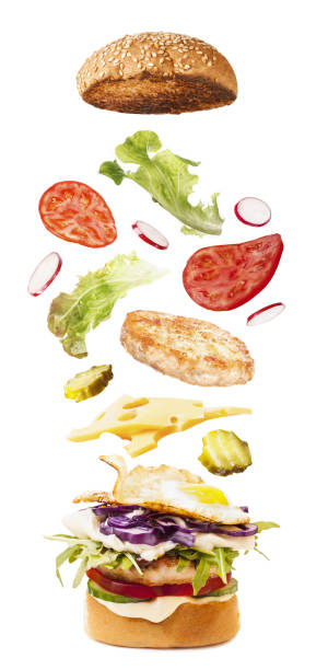 istock Big tasty burger with flying ingredients on white 1051541438