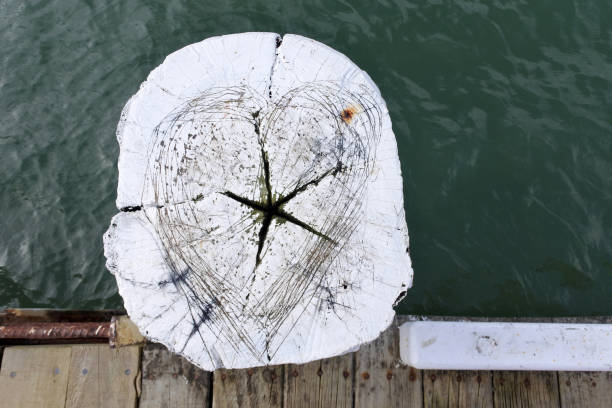 Above view of a wooden pole with heart and star shape on a boat jetty.