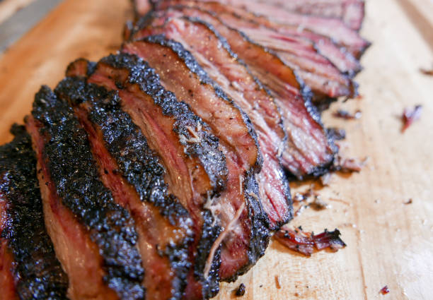 Sliced smoked brisket on a wooden cutting board. Brisket barbecue smoked food stock pictures, royalty-free photos & images