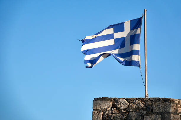 istock Greek flag on blue sky 1051566460