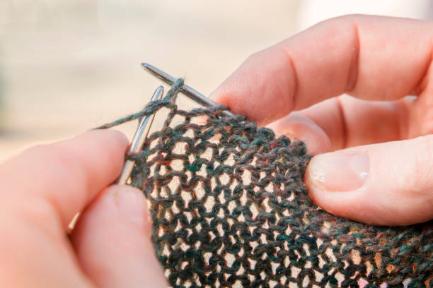 istock Female hands knit clothing from wool on knitting needles. 1051569232