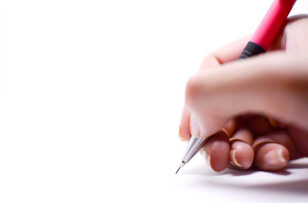istock A woman's hand is writing something with a pink pencil, isolated on white background. 1051588076