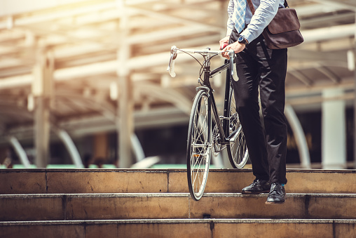 Goto empresario sosteniendo bicicleta inteligente trabajo en vereda urbana en hora punta - medio ambiente y el concepto de estilos de vida photo