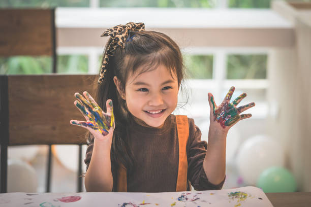 istock kids with dirty painted hand in art classroom 1051600034