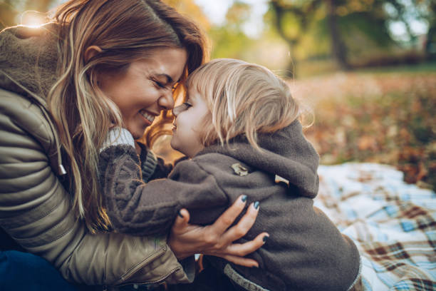 mãe afetuosa e filho se divertindo enquanto esfregando os narizes na natureza. - family child mother autumn - fotografias e filmes do acervo