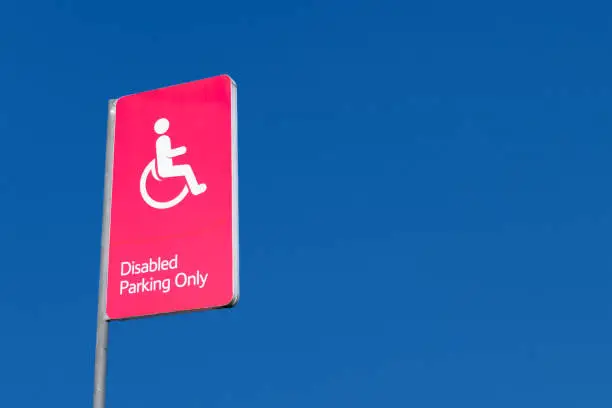 Disabled Badge Holders Only at Car Park Sign Post in Blank Blue Sky uk