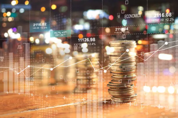 Photo of Double explosure with businesss charts of graph and rows of coins for finance at night city background.