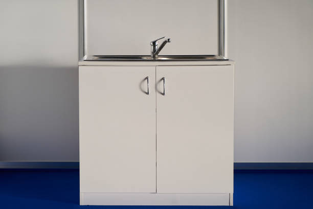 istock White cabinet kitchen sink with chrome water tap 1051620358