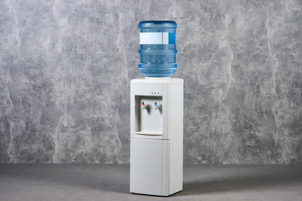 white water cooler gallon au bureau sur fond de mur texturé gris - fontaine photos et images de collection