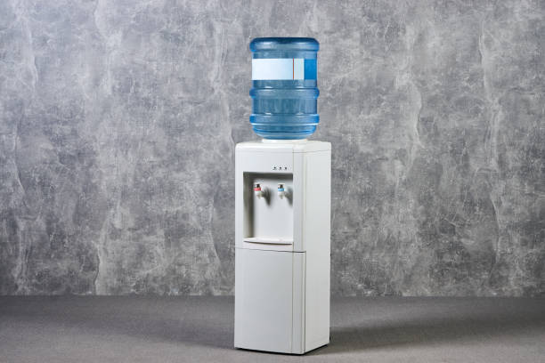 istock White water cooler gallon in office against gray textured wall background 1051620580