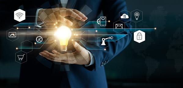 Business innovation technologies concept. Businessman's hand holding glowing light bulb with icon technology network connection. Futuristic digital marketing and innovative development on modern interface background.