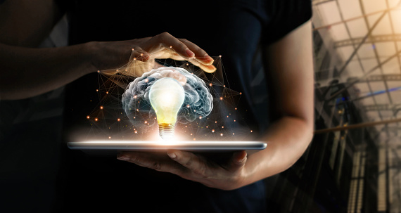 Human holding tablet with light bulb future technology, brain and network connection communication background, science, innovation and creative idea concept.