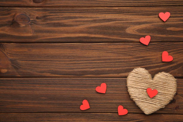 istock Thread heart with a wooden red hearts on a brown background 1051638764