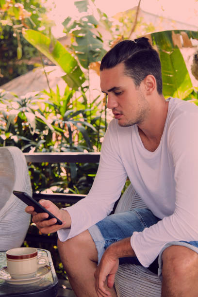 istock Modern man drinking coffee and using cellphone outdoors. 1051644350