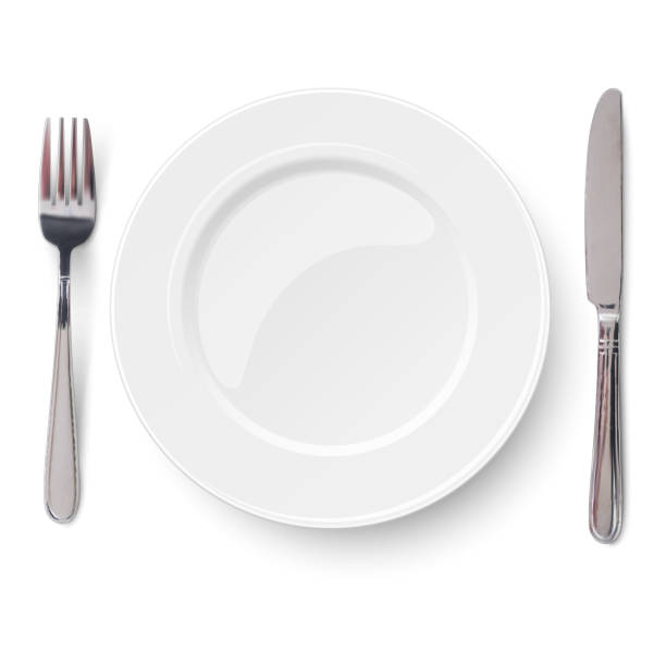 Empty plate with knife and fork isolated on a white background. View from above. Empty plate with knife and fork isolated on a white background. View from above. empty plate stock illustrations