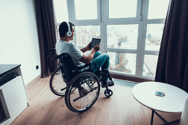 istock Smiling Disabled Man in Headphones Uses Tablet 1051655742